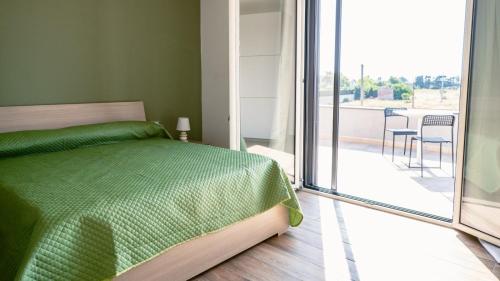 una camera con letto verde e balcone di Tenuta Papola B&b a Brindisi