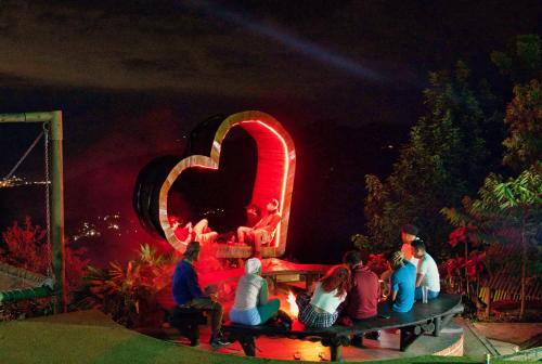 a group of people sitting on a bench in front of a sign at Hostal Sierra Minca in Minca