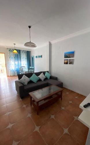 een woonkamer met een bank en een salontafel bij Casa Tagoror in Punta Umbría