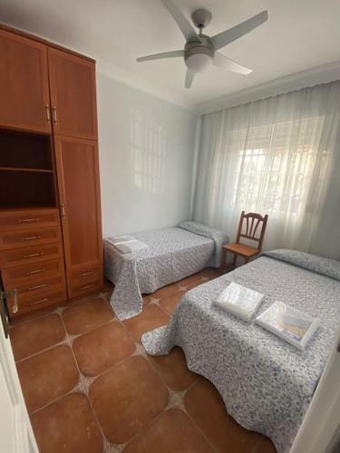 een slaapkamer met 2 aparte bedden en een dressoir bij Casa Tagoror in Punta Umbría