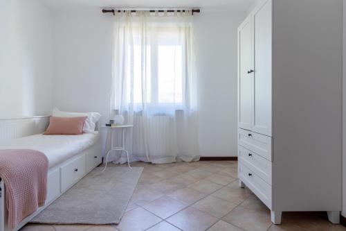 a bedroom with a white bed and a window at Profumodilago in Angera