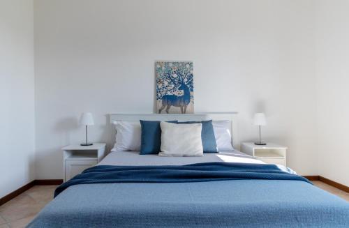 1 dormitorio con 1 cama azul y 2 lámparas en Profumodilago, en Angera