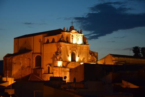 a building with a clock tower at night at Casa Matea in Noto