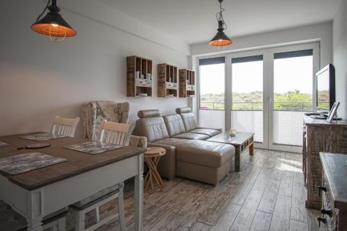 un salon avec un canapé et une table dans l'établissement Apartament na wydmie - Darłowo, à Darłowo