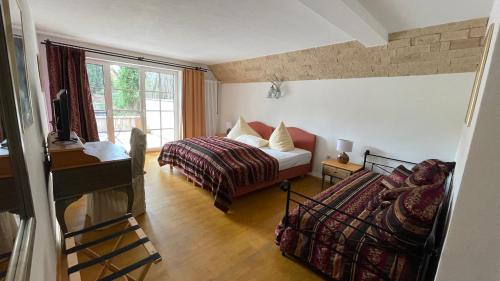 a bedroom with a bed and a desk and a window at Gästehaus Eschment in Bissersheim
