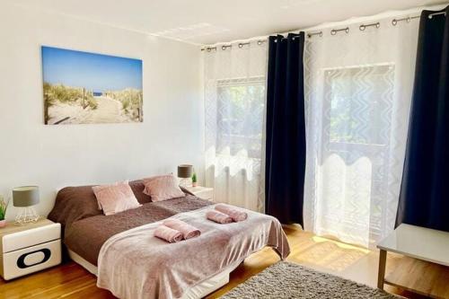 1 dormitorio con 1 cama con 2 toallas rosas en Holiday flat, Dabrowa, en Gostyniec