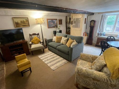a living room with a couch and a tv at Minehead Forget me not Cottage in Minehead