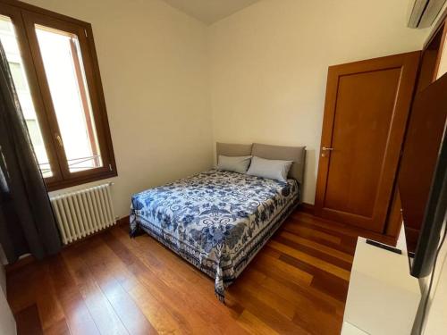 パドヴァにあるLe Palme - Appartamento elegante e moderno con garage privatoのベッドルーム1室(ベッド1台付)、窓、ドアが備わります。