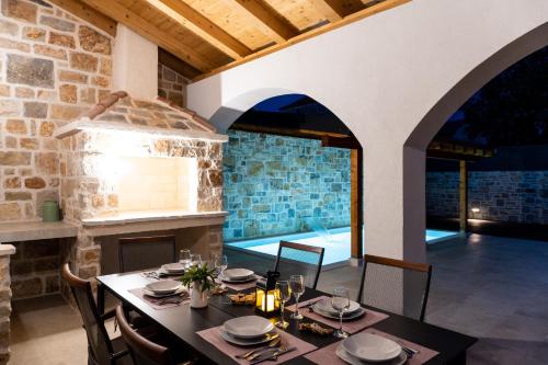 a dining room with a table and a stone wall at Holiday Home Rakova in Gornje Selo