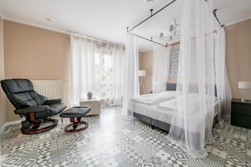ein Schlafzimmer mit einem Bett und einem schwarzen Stuhl in der Unterkunft Aparthotel Alma Bonn in Bonn