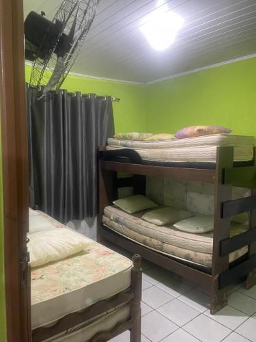 a room with three bunk beds in a room at Casa - Prado - Bahia in Prado