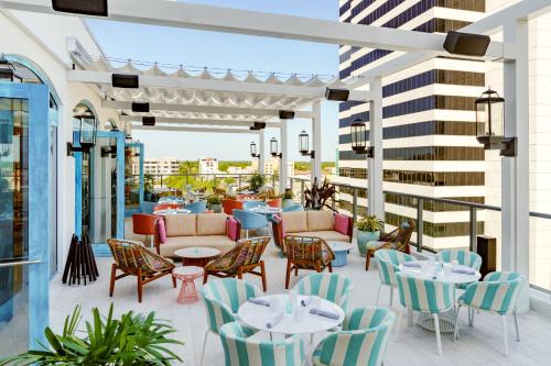 a patio with tables and chairs on a building at AC Hotel St Petersburg Downtown in St. Petersburg