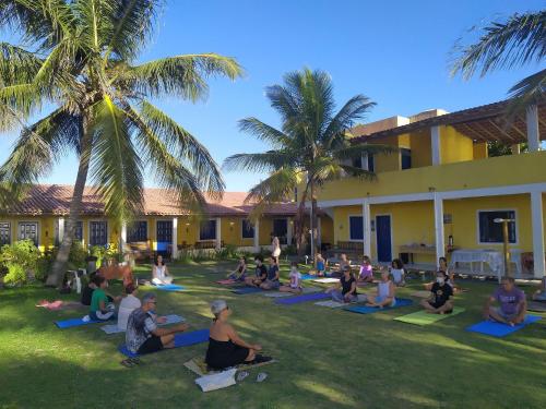 um grupo de pessoas fazendo yoga no quintal de um edifício em Quintal da Praia em Prado