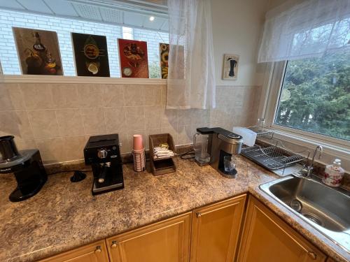 een keuken met een wastafel en een aanrecht met een koffiezetapparaat bij Spacious private room near Finch station in Toronto