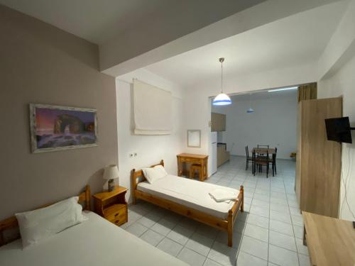 パルガにあるNAKOU FREIDERIKI ANTHOUSA PARGAsのベッド2台とダイニングルームが備わる客室です。