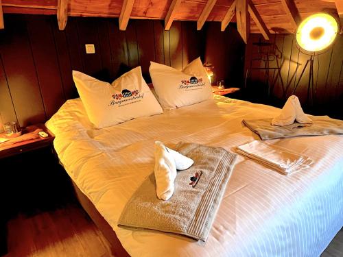 a bed with two towels and a tray on it at Burgemeestershof in Wetteren