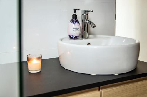 a bathroom with a sink and a candle and a glass at Villa Anthea in Willemstad