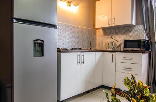 a kitchen with white cabinets and a refrigerator at Villa Anthea in Willemstad