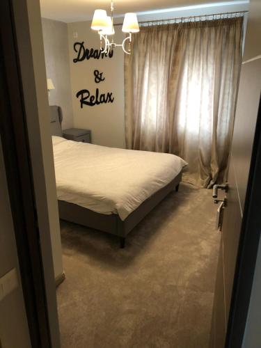 a bedroom with a bed and a sign on the wall at Page1 Ultracentral Apartament in Târgovişte