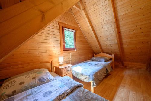 a room with two beds in a log cabin at Domki nad morzem - Nevada in Darlowko