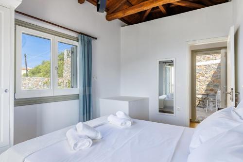 a white bedroom with a bed with towels on it at Villa Soultani in Glóssa