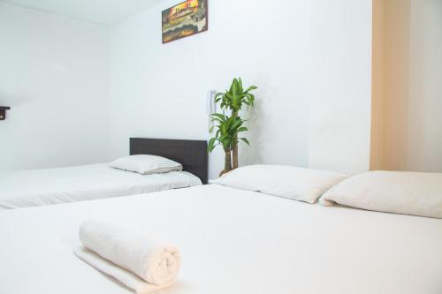 two beds sitting next to each other in a room at Hotel El Palacio Del Rey in Duitama