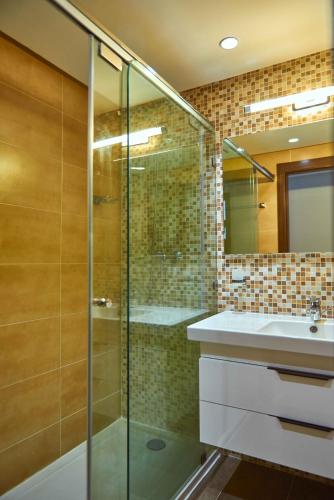 a bathroom with a glass shower and a sink at Tanger City Center Residences Suites & sea view in Tangier