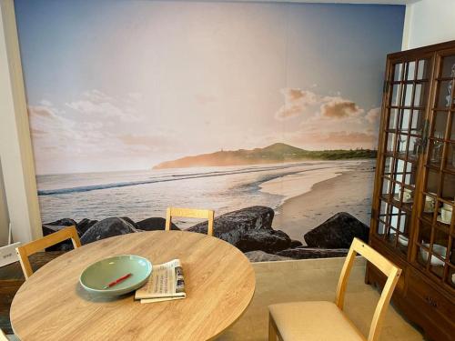 a table and chairs with a painting of a beach at Porta da Vila by Oktheway in Puentedeume