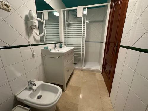 ein Bad mit einem WC, einem Waschbecken und einer Dusche in der Unterkunft Porta da Vila by Oktheway in Puentedeume