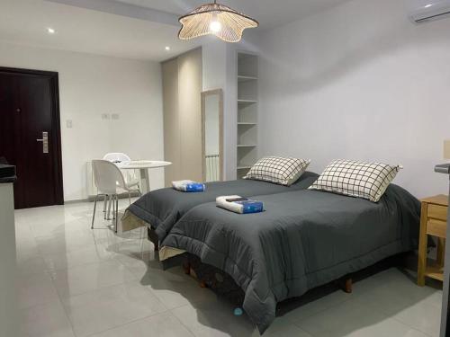 1 dormitorio con 1 cama grande y 1 mesa en Adrogué Apartments, zona céntrica de Adrogué en Adrogué