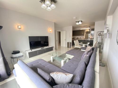 a living room with a couch and a tv at Contemporary City Centre Apartment in The Aspect in Cardiff