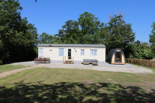a small white caravan with a tent in a yard at Hof Nieuwerkerk Chalet 2 in Arnemuiden