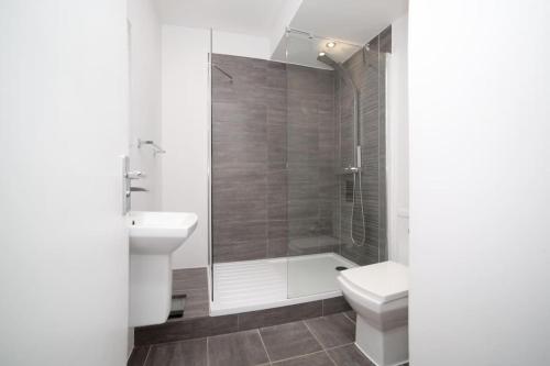 e bagno con doccia, servizi igienici e lavandino. di Contemporary City Centre Apartment in The Aspect a Cardiff