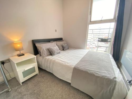 una camera con un letto bianco e una finestra di Contemporary City Centre Apartment in The Aspect a Cardiff