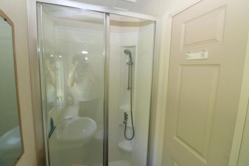 a person taking a picture of a shower in a bathroom at Hof Nieuwerkerk Chalet 2 in Arnemuiden