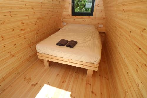 een kleine kamer met een bed in een houten hut bij Hof Nieuwerkerk Chalet 2 in Arnemuiden