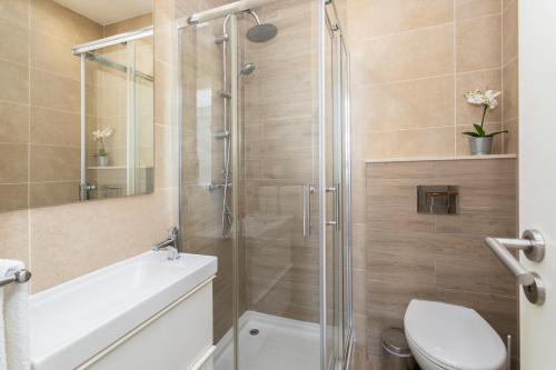 een badkamer met een douche, een toilet en een wastafel bij Stunning Studio with Beach Front- Astro Quarteira by Centralgarve in Quarteira