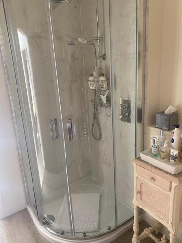 a shower with a glass enclosure in a bathroom at Newmans Cottage in Burford