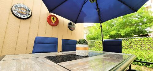a table with a blue umbrella and blue chairs at Hawaii-Peg in Winnipeg