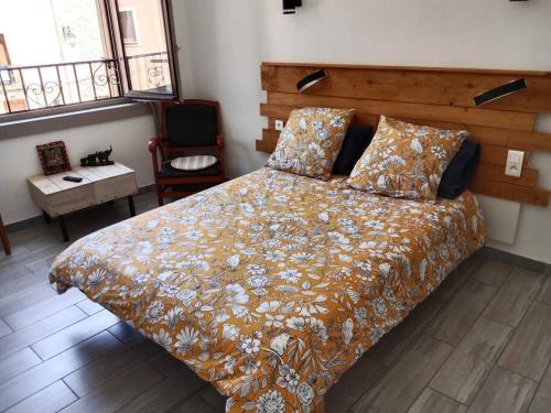 a bedroom with a bed and a chair and windows at L'Astré in Loupian