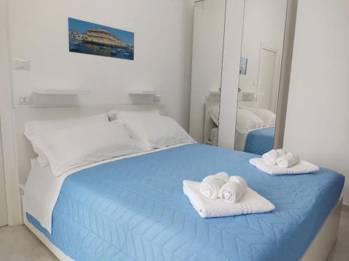 Un dormitorio con una cama azul con toallas. en Mare Luna Apartment, en Bari