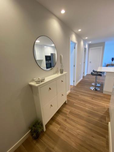 een badkamer met een wastafel en een spiegel bij Apartamento Arousa Mar in Villanueva de Arosa