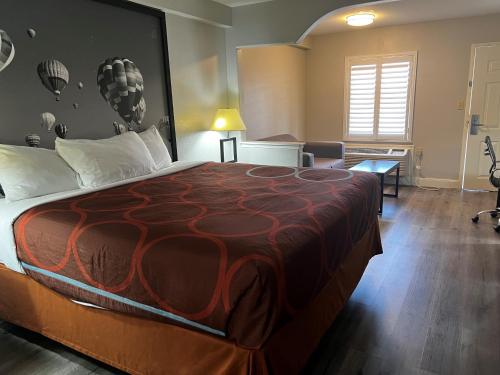 um quarto de hotel com uma cama grande e um sofá em Super 8 by Wyndham Baytown/Mont Belvieu em Eldon