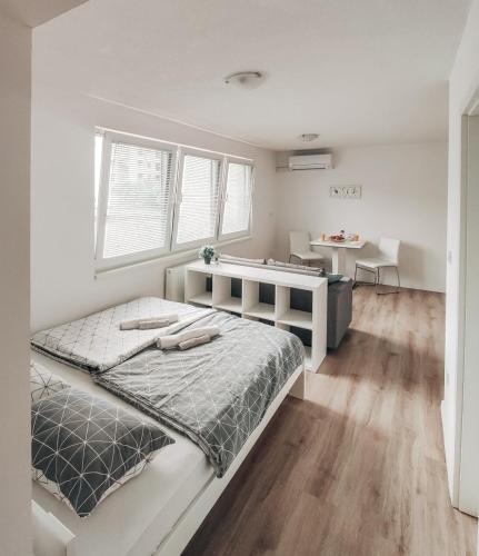 een witte slaapkamer met een groot bed en een bureau bij Studio Apartment Sanya #2 in Ljubljana