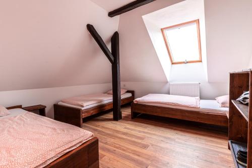 a room with two beds and a window at Bike Bistro a penzion U Všech andělů in Nové Město pod Smrkem