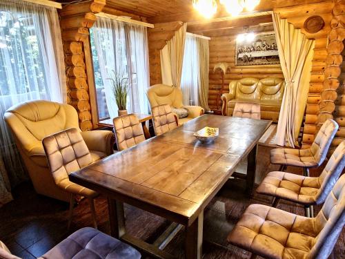 uma sala de jantar com uma mesa de madeira e cadeiras em Gostynniy Dvir Коттеджи em Migovo