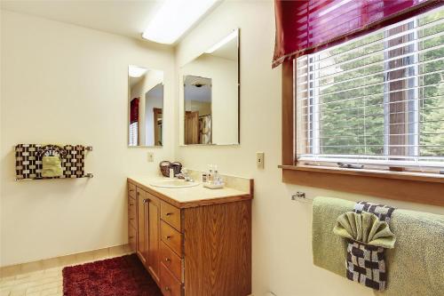 a bathroom with a sink and a mirror and a window at Mountain Falls in Stowe
