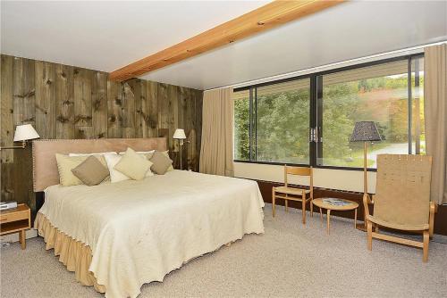 a bedroom with a large bed and a large window at Notchbrook 2AB in Stowe