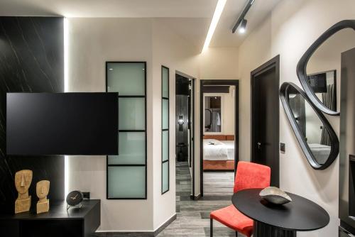 a room with a table and a chair and a bed at Maison Aqua Suite with Private mini pool jacuzzi in Hersonissos