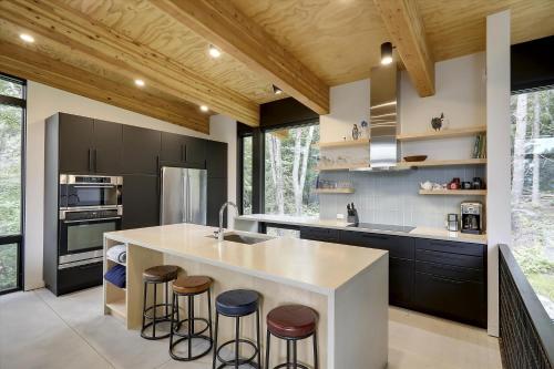 a kitchen with a large island with stools at Sterling Treehouse in Stowe